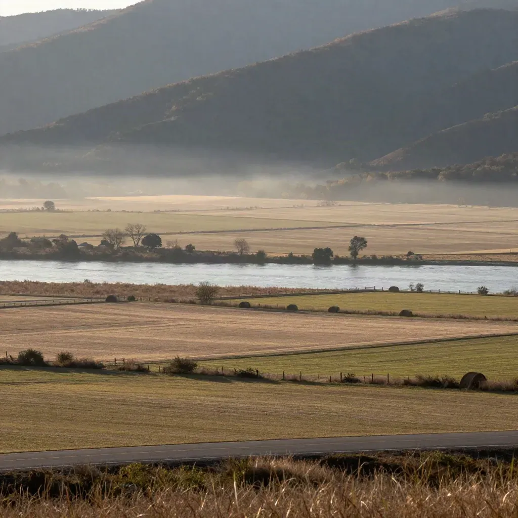 Shenandoah Valley overlook with farms, river flats, and distant mountains in warm evening haze.